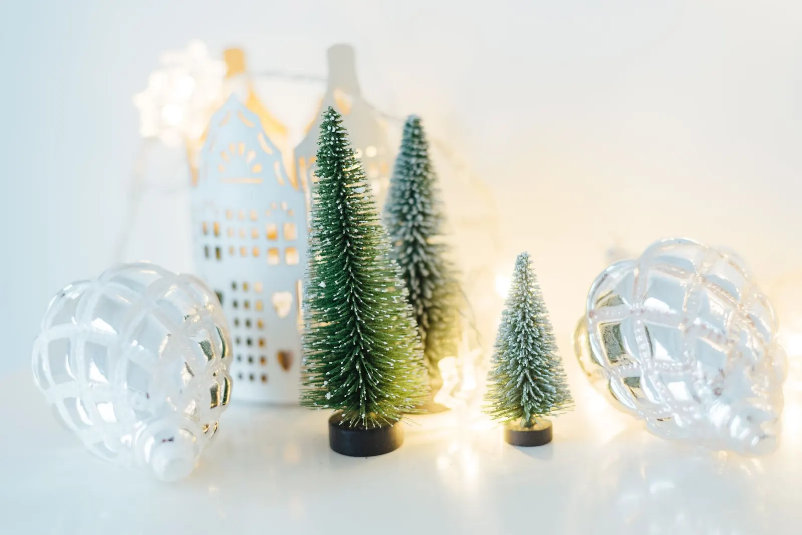 Small tabletop Christmas tree with gold ornaments on a wooden side table next to a sofa