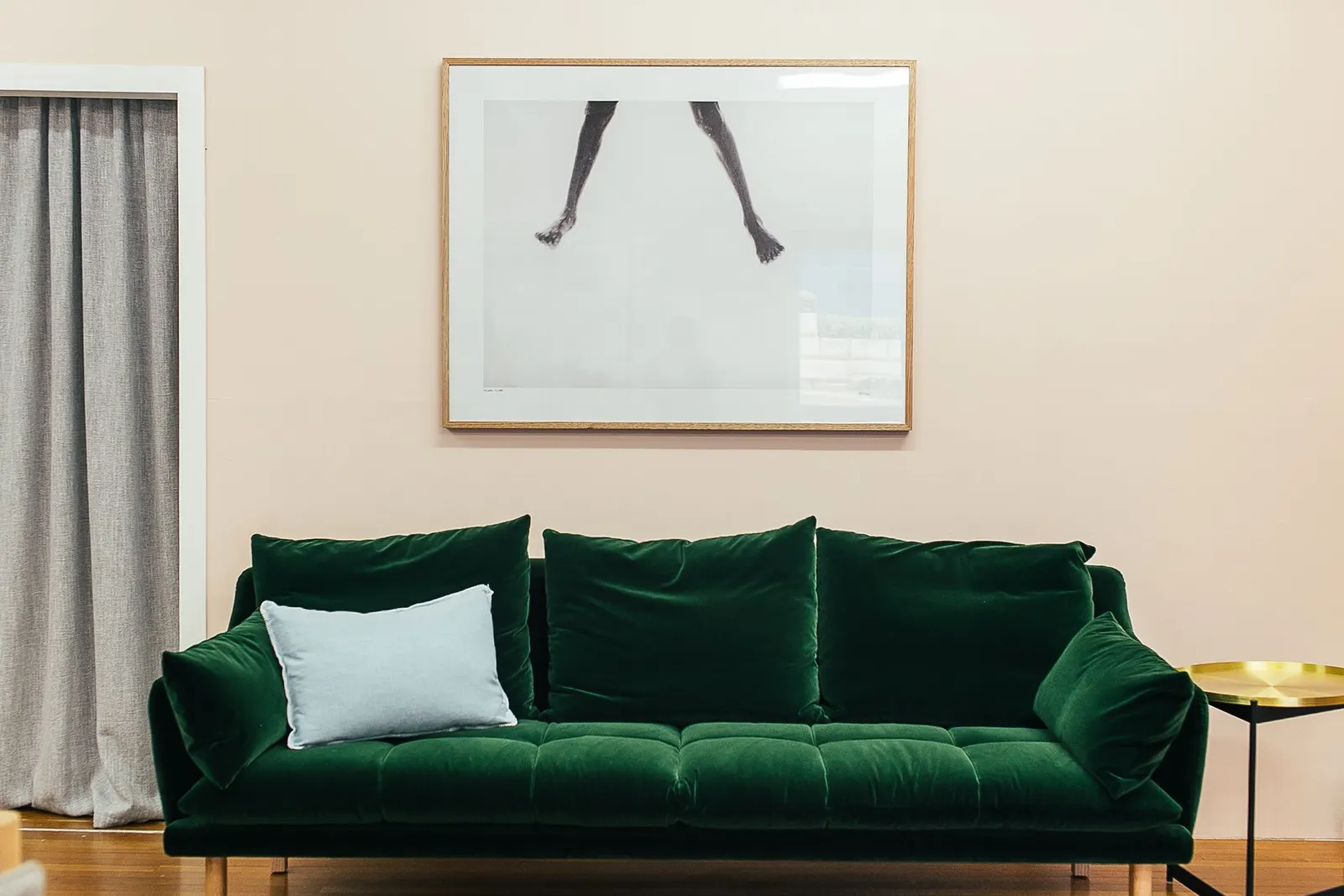 Living room with a sage green painted side table, green throw and cream sofa
