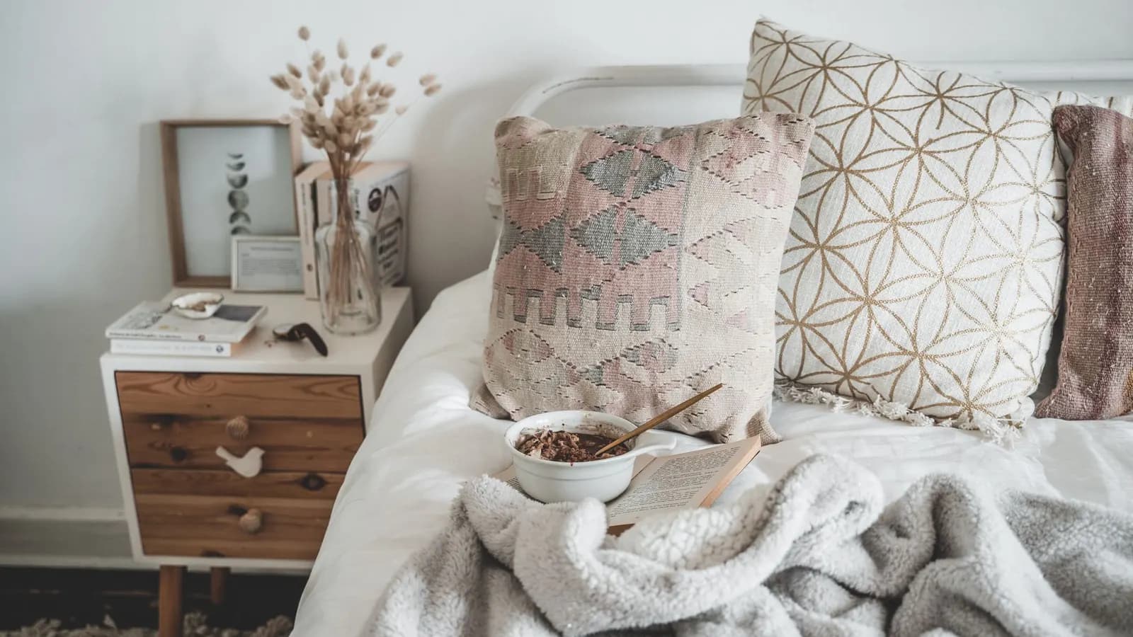 Warm and inviting bedroom scene featuring pillows and a breakfast setup, perfect for a relaxed morning.