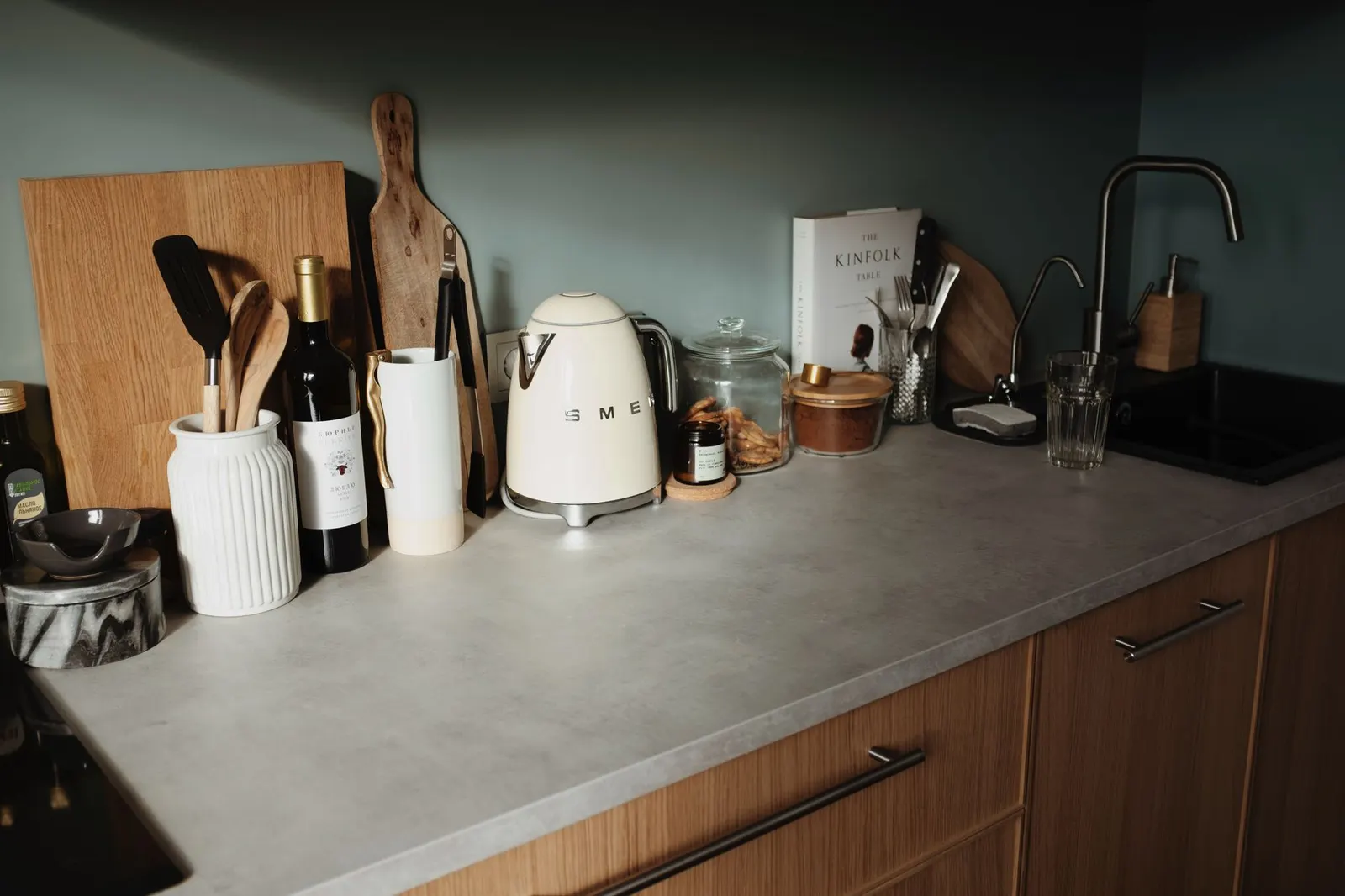 Small rental kitchen counter with one skillet, a saucepan, a cutting board and a few white plates