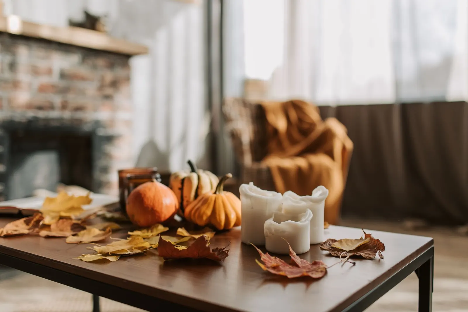 Warm flameless pillar candles and fairy lights glowing on a fall dinner table
