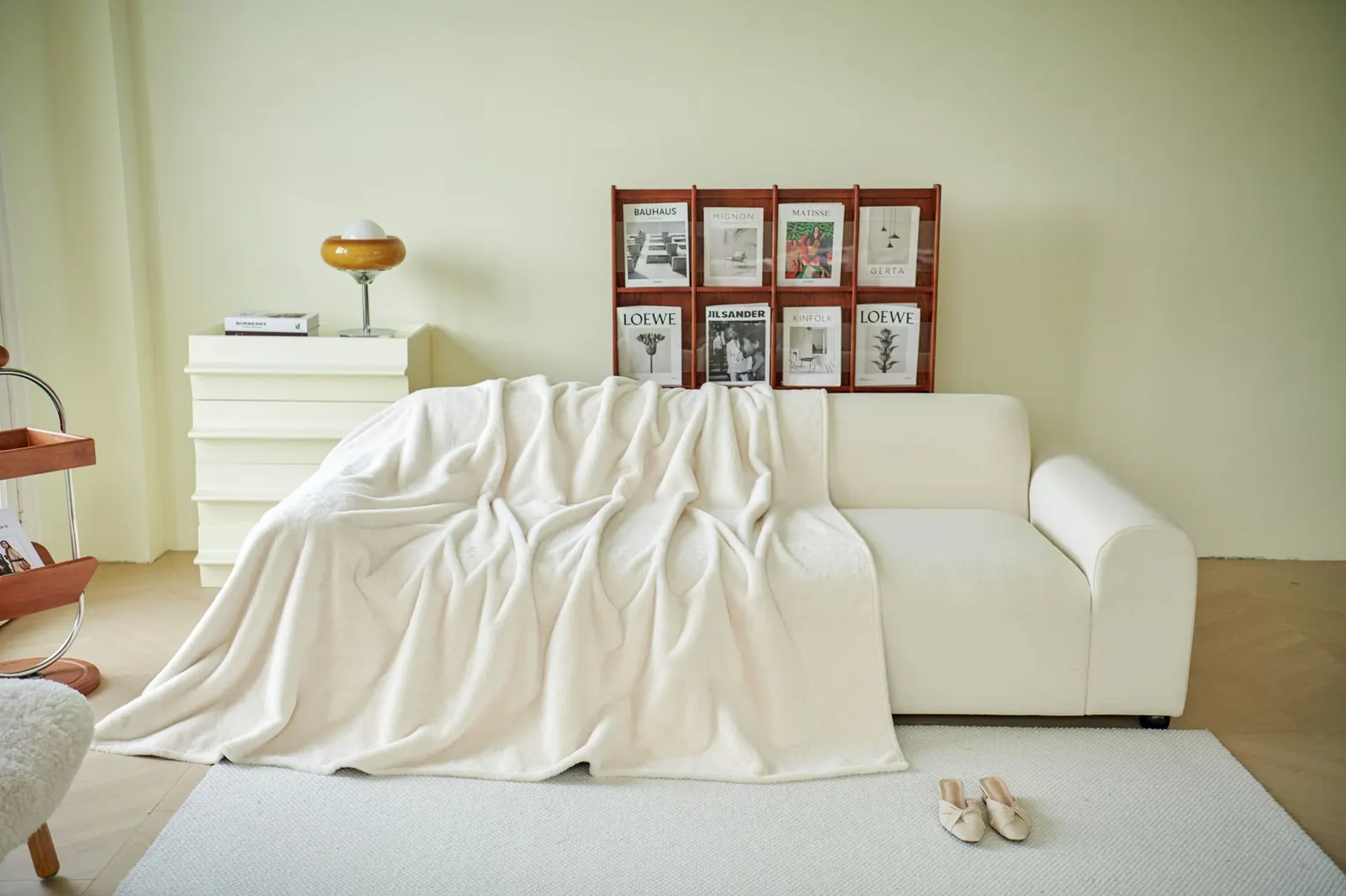 White sofa covered with a soft white blanket in a bright living room