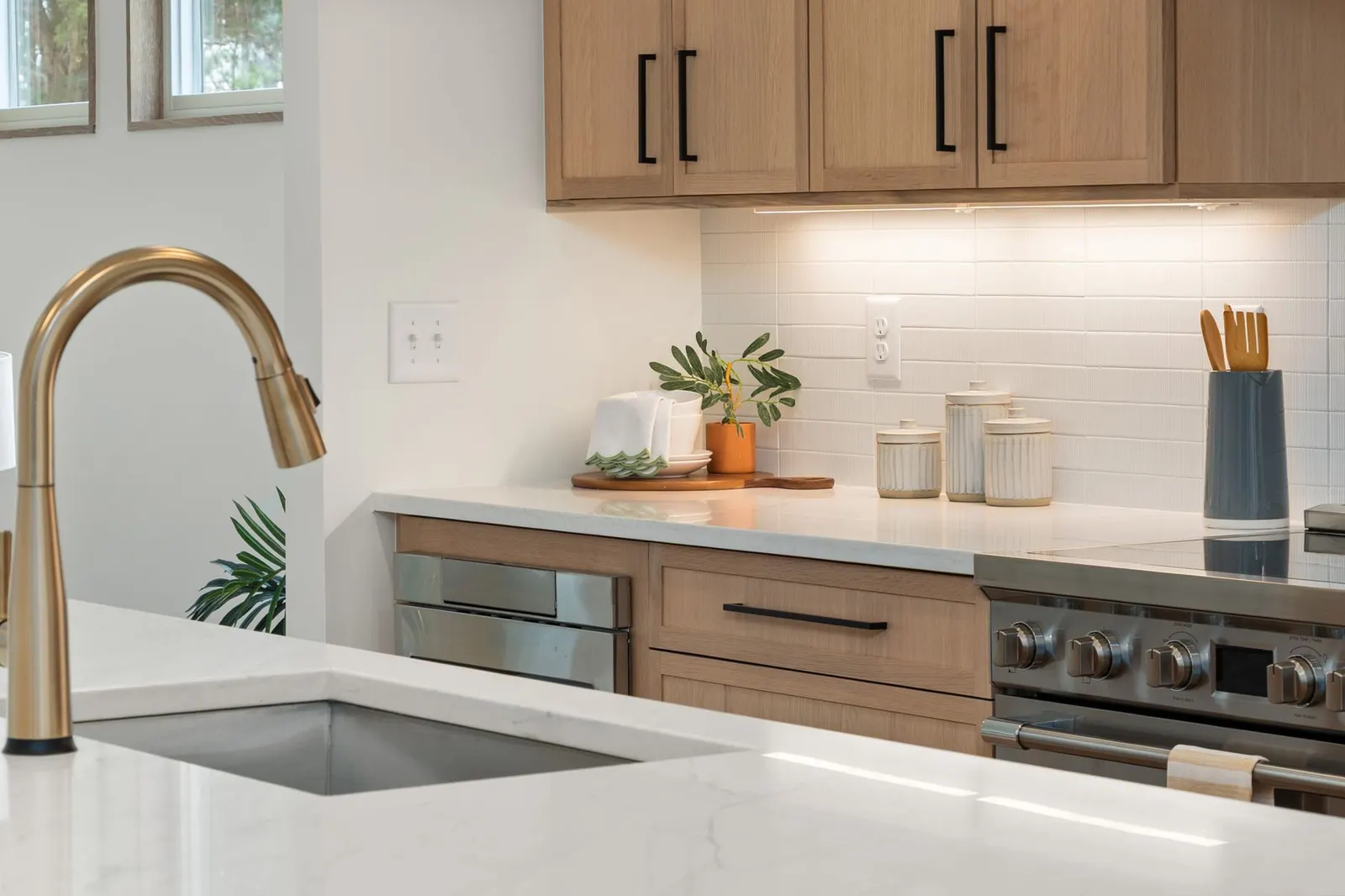 Elegant modern kitchen featuring marble countertops, wooden cabinets, and brass fixtures.